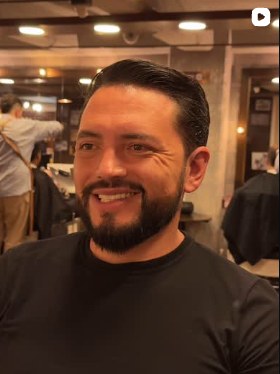 Cliente con barba perfilada sonriendo en Mustache's